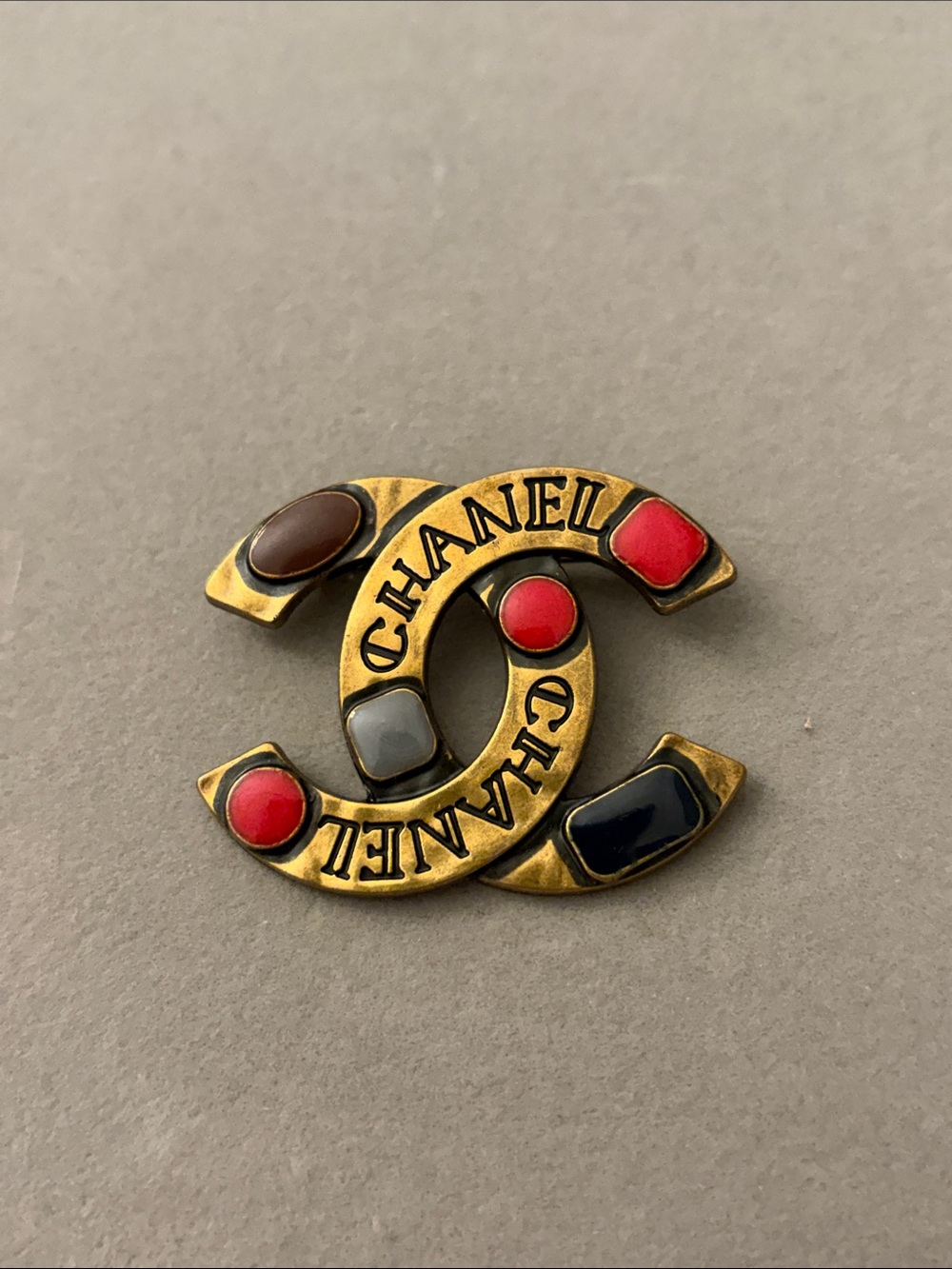 Gold Tone CC Brooch with Red, Black, Brown and Gray Accents